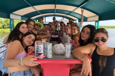 a group of people sitting at a table with an umbrella