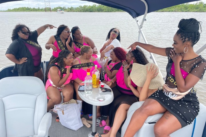 a group of people sitting next to a body of water