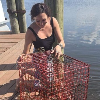 a woman sitting at a table in front of water